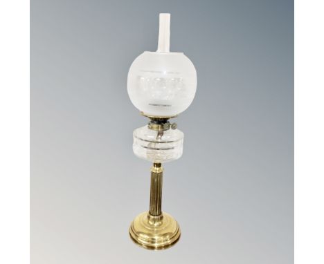 A Victorian brass column oil lamp with glass reservoir, chimney and shade 