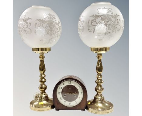 A pair of brass table lamps with glass ball shades together with an oak cased Smiths mantel clock 