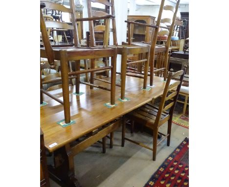 An Ercol rectangular pine dining table, on tablet-end supports, together with a set of 6 Ercol ladder-back dining chairs (4 a