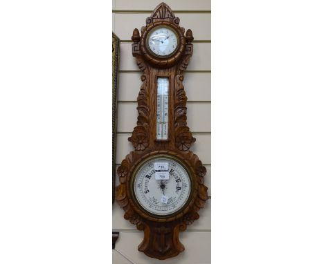 A Victorian carved oak-cased aneroid wall barometer, with inset clock, ceramic dials and carved anchor design case, height 76