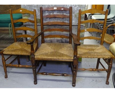A Lancastrian oak ladder-back rush-seated elbow chair, and 2 similar side chairs (3) 