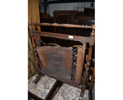 An early 20th Century firescreen having turned oak frame and tooled leather panel and strap work showing significant damage
