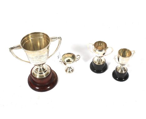 Three silver sporting trophies and a silver-plated trophy. The largest engraved with News of the World Individual Darts Champ