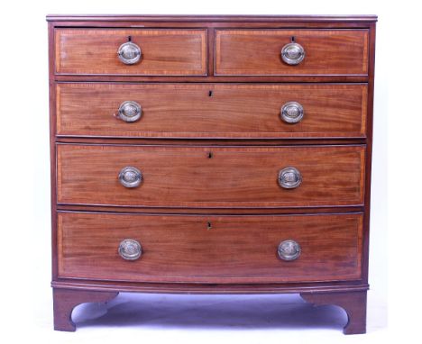 A 19TH CENTURY MAHOGANY AND CROSS BANDED SATINWOOD BOW FRONTED CHEST of two short and three long drawers raised on bracket fe