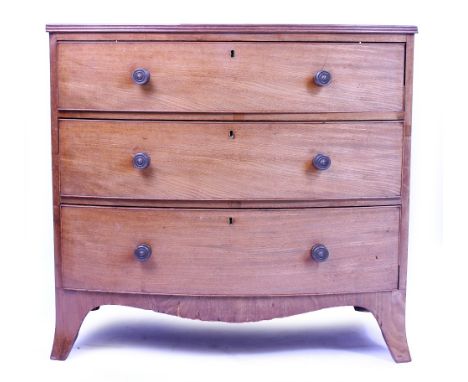 A LATE GEORGE III BOW FRONTED MAHOGANY CHEST OF THREE LONG DRAWERS with brass knob handles and splayed bracket feet, 92cm wid