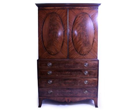 A 19TH CENTURY MAHOGANY LINEN PRESS  with twin doors having inset oval panels above four long graduated drawers, raised on sp