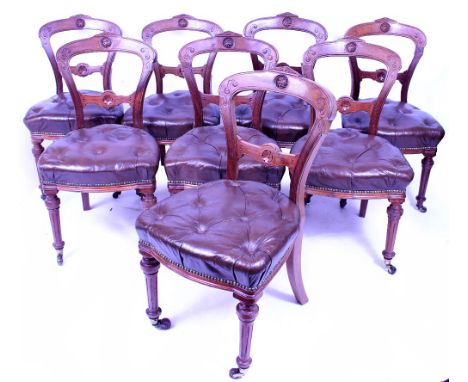 A SET OF EIGHT VICTORIAN BALLOON BACK DINING CHAIRS with leather button upholstered seats, fluted legs and brass and ceramic 