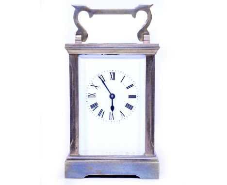 A BRASS CARRIAGE TIMEPIECE OR CLOCK the enamelled dial with roman numerals, 8cm wide x 15cm high with handle up