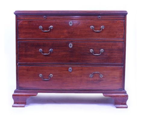 A GEORGE III MAHOGANY CHEST OF THREE LONG DRAWERS with brass swan neck handles, having a slide and raised on ogee bracket fee