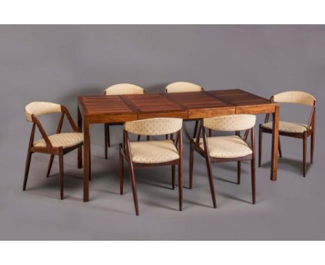 A DANISH ROSEWOOD DINING SUITE by Vejle Stole Mobelfabrik, 1970's, the extending oblong table with panelled top with hinged f