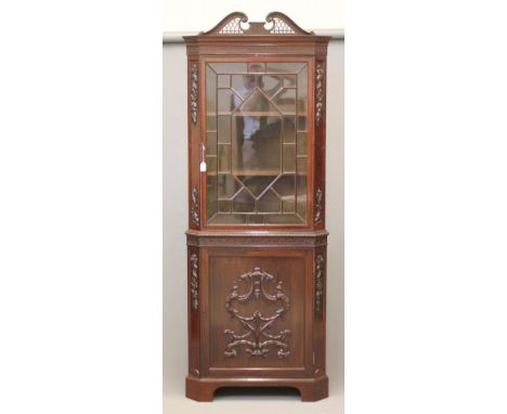 AN EDWARDIAN MAHOGANY STANDING CORNER CUPBOARD in the Georgian rococo style, the moulded cornice with scrolled pierced fret p