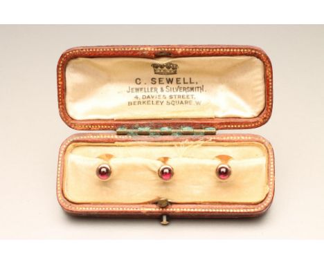 A SET OF THREE 9CT GOLD SHIRT STUDS each set with a cabochon polished ruby, cased (Est. plus 21% premium inc. VAT)
