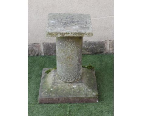 A SANDSTONE WALL SUNDIAL, dated 1711, (lacking gnomen), 18" x 17", now mounted on a cylindrical sandstone stem and sloping sq