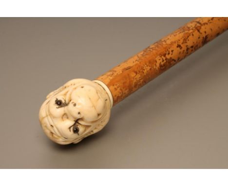 A VICTORIAN WALKING STICK, the malacca shaft with copper tip, carved ivory grip as a monkey head with glass eyes, 33 1/4" lon