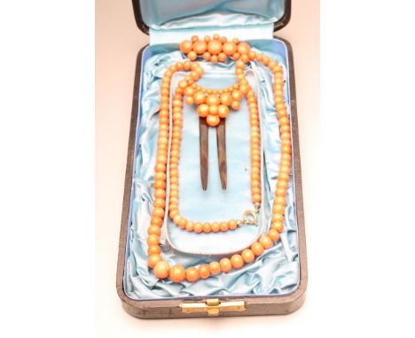 A VICTORIAN CORAL SUITE comprising a 24 1/2" long single string of graduated beads, crescent shaped hinged two prong hair com