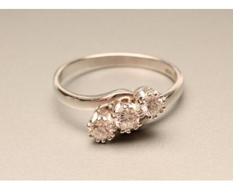 A THREE STONE DIAMOND RING, the brilliant cut stones each of approximately 0.12cts in a crossover setting to a plain 18ct whi