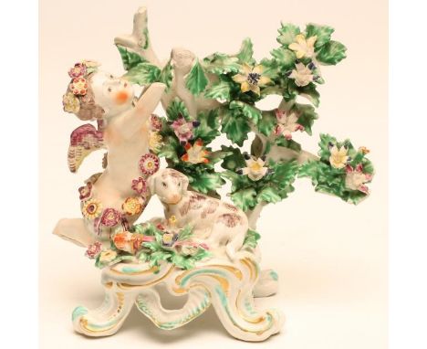 A BOW PORCELAIN FIGURAL CANDLESTICK BASE, c.1760, modelled as a flower garlanded putti balancing beside bocage, a recumbent d