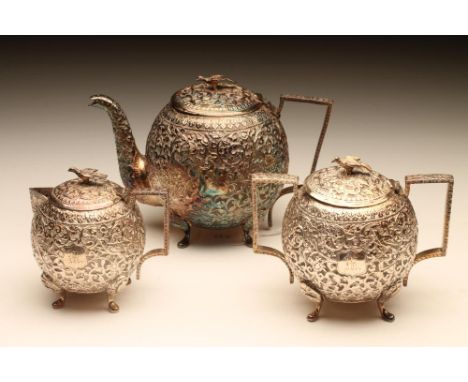 AN EASTERN WHITE METAL THREE PIECE TEA SERVICE, late 19th century, unmarked, of globular form, all over chased with scrolling