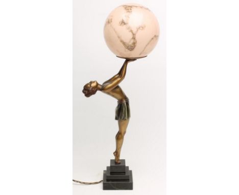 AN ART DECO BRONZED SPELTER FIGURAL LAMP BASE modelled as a young woman, her outstretched arms holding a pink marbled glass g