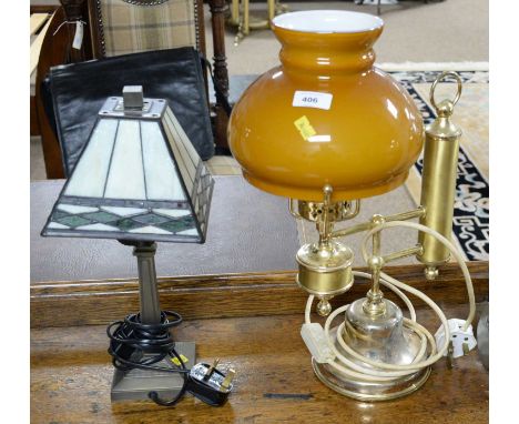 A gilt metal table lamp, of carriage lamp design, with amber glass shade, wired for electricity, 43cms high overall; together