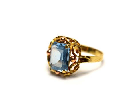 A topaz ring, the rectangular step cut blue topaz in scrolling mount, on 14ct yellow gold shank, ring size N, 2.9g gross. 