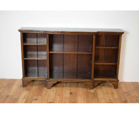A 20th Century Georgian style mahogany breakfront open-faced bookcase, the flared top over three sectional bookcases raised o