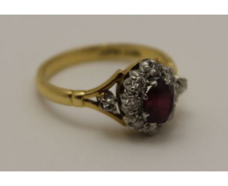 AN 18CT GOLD RUBY RING, the central stone surrounded by diamonds, ring size; 'L', gross weight; 3.5g 