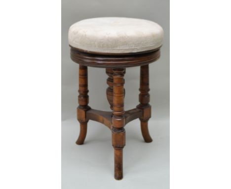 A LATE 19TH CENTURY WALNUT CIRCULAR TOPPED PIANO STOOL having revolving height adjustable pad top on four ring turned support
