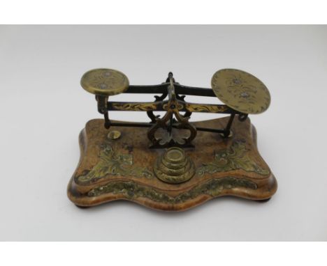A LATE VICTORIAN POSTAL BALANCE SCALE, decoratively engraved and brass mounted, serpentine base, the graduated weights also e