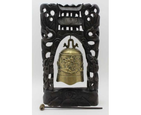 AN EARLY 20TH CENTURY FAR EASTERN CAST BRASS BELL, dragon decoration, on carved wood stand, with hammer, the stand 44cm high 