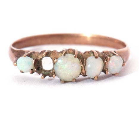 Four stone opal ring featuring four graduated round opal cabochons (one stone missing), all in an unmarked yellow metal mount