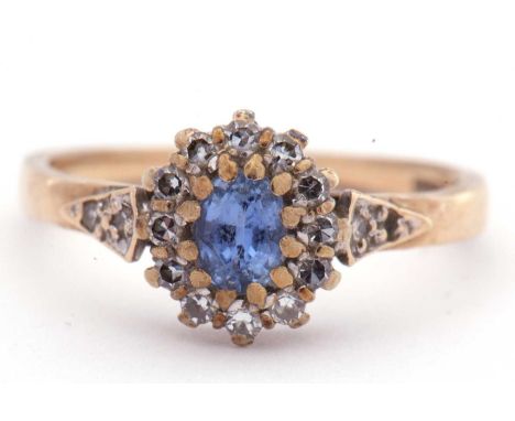 9ct gold sapphire and diamond cluster ring, the pale oval shaped sapphire multi-claw set and raised above a diamond surround,