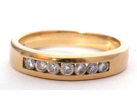 Seven stone diamond ring, channel set with seven small round brilliant cut diamonds, stamped 750, g/w 5.0gms, size M