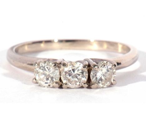 Three stone diamond ring featuring three round brilliant cut diamonds, 0.20ct each approx, raised in coronet settings, size M
