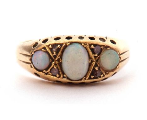 Antique opal and diamond ring centring an oval cabochon opal, flanked by two small round opal cabochons and highlighted betwe