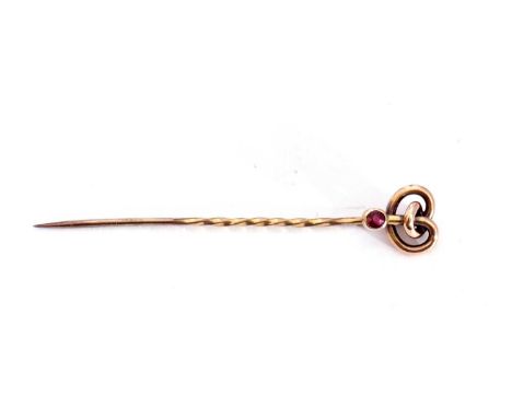 9ct stamped stick pin of a knotted design with a small bezel set ruby highlight