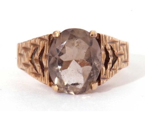 9ct gold and quartz set ring, the central oval faceted quartz raised between pierced textured shoulders, Birmingham 1979, siz