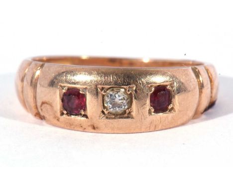 Diamond and ruby three stone ring centring an old cut diamond flanked by two round cut rubies, each individually engraved set