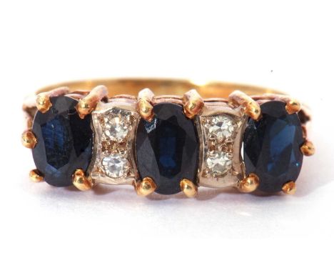 18ct gold dark sapphire and diamond ring, a design featuring three oval cut sapphires, highlighted between with two pairs of 