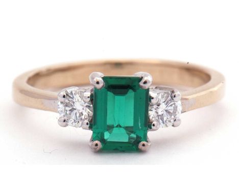 Emerald and diamond three stone ring, the step cut emerald flanked by two round brilliant cut diamonds 0.15ct each approx, si