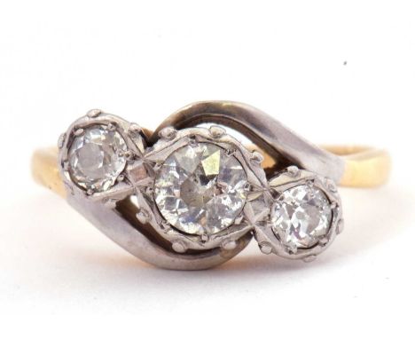 A three stone diamond ring featuring three graduated old cut diamonds, 0.45ct approx, bezel set between cross over shoulders 