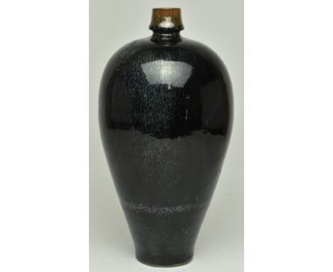 A Chinese Kangxi period mirror-black glazed pottery vase. The vase with an ovoid body sweeping up from narrow base to broad s