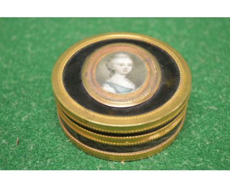 Circular tortoiseshell snuff box with gold mounted band decoration, the lid having oval portrait of a young lady wearing a gr