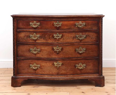 A George III mahogany commode,of serpentine outline, the four graduated cockbeaded drawers set between blind fret-carved edge