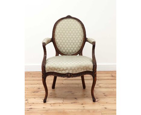 A carved beech open armchair,c.1775, in the manner of Thomas Chippendale, with an oval padded back, padded arms and an overst