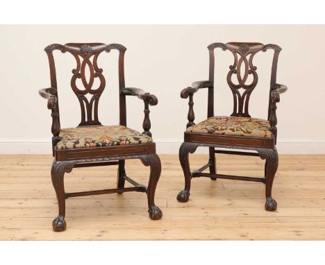 A pair of Irish mahogany open armchairs,18th century and later, in the Chippendale taste, each with an acanthus-carved top ra