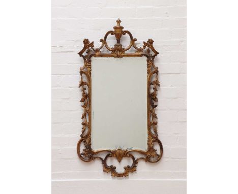 A George III-style giltwood wall mirror,19th century, the bevelled plate within a frame, surmounted by an urn, carved with sc