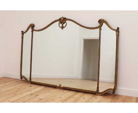 A large gilt-framed overmantel mirror,in the rococo manner, with scroll and swept frame, burnished gilt leaf carved crest and