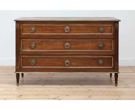 A Louis XVI walnut commode, late 18th century, with three graduated drawers, each with brass mouldings and ring handles, flan