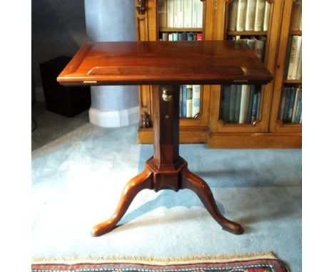 A George III mahogany tripod library reading table, the rectangular top with detachable rest, hinged with strut support, on t